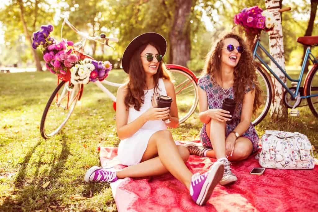 Two best friends drinking coffee to go in nature